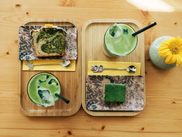 Zwei Stück Matcha-Kuchen auf einem Tablett.