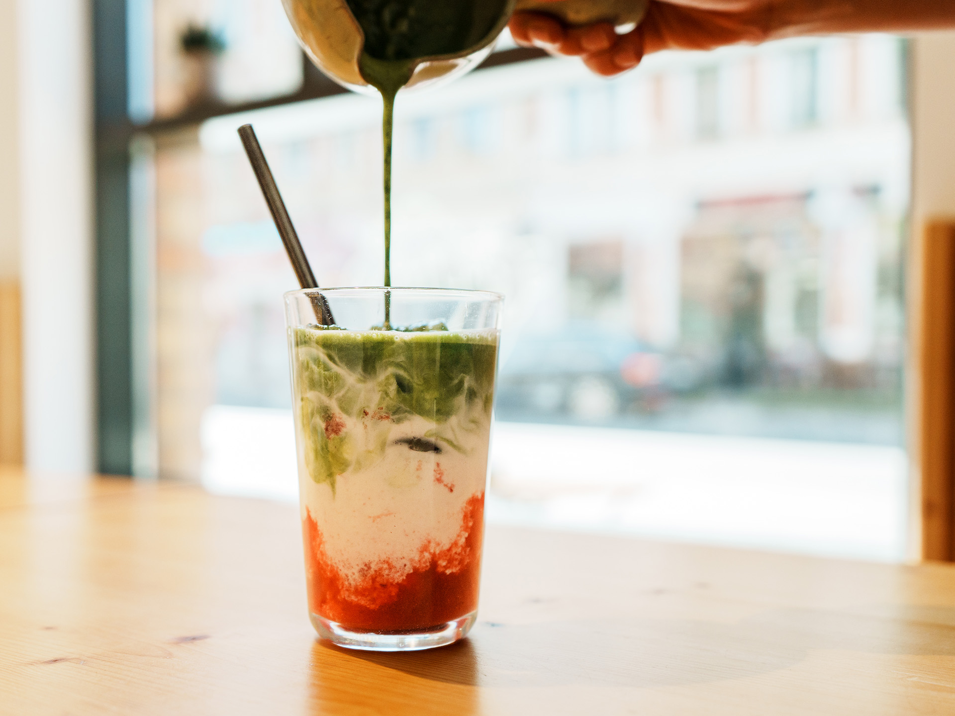 Iced Matcha Latte mit einem Eiswürfel in Katzenform.